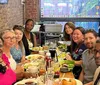 A group of people is enjoying a meal together at a table in a restaurant with brick walls and a stained glass window