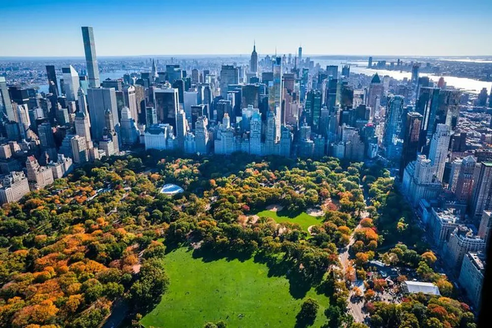 This is an aerial view of Central Park surrounded by the skyscrapers of Manhattan showcasing a striking contrast between nature and urban development