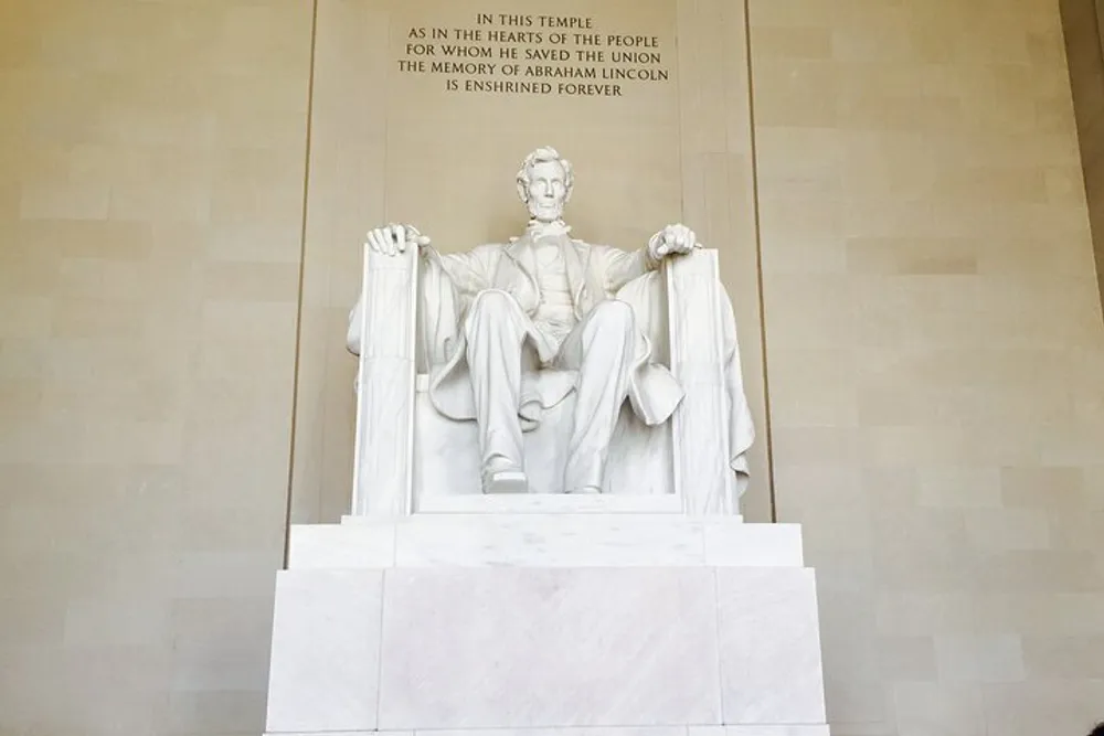 The image features the iconic statue of Abraham Lincoln seated in contemplation at the Lincoln Memorial in Washington DC with an inscription above honoring his memory