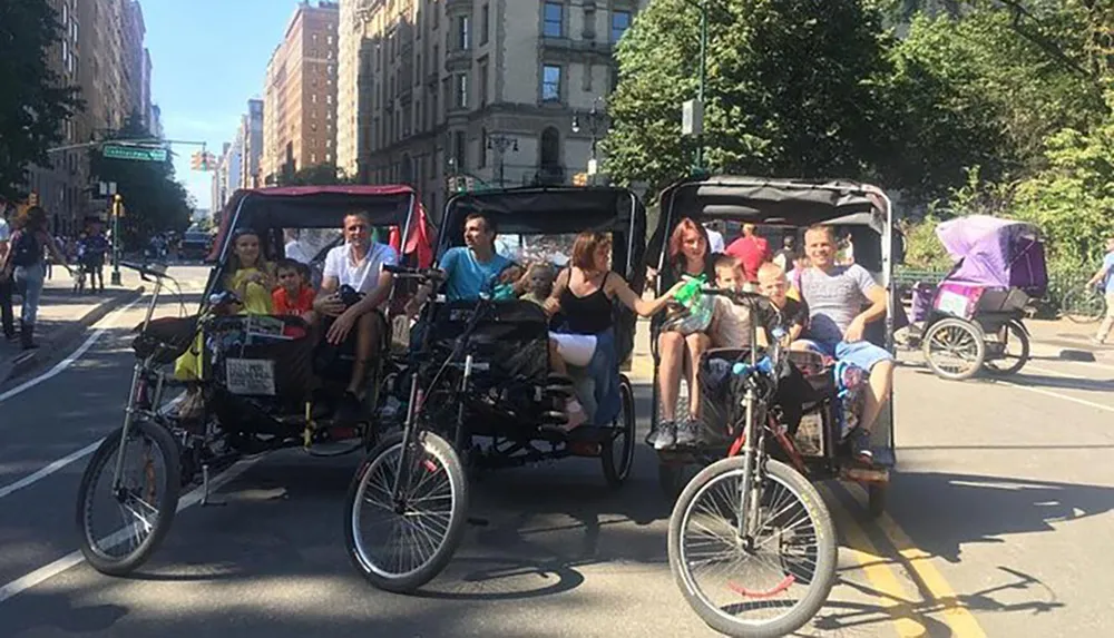 A group of smiling people is enjoying a ride in pedicabs on a sunny city street