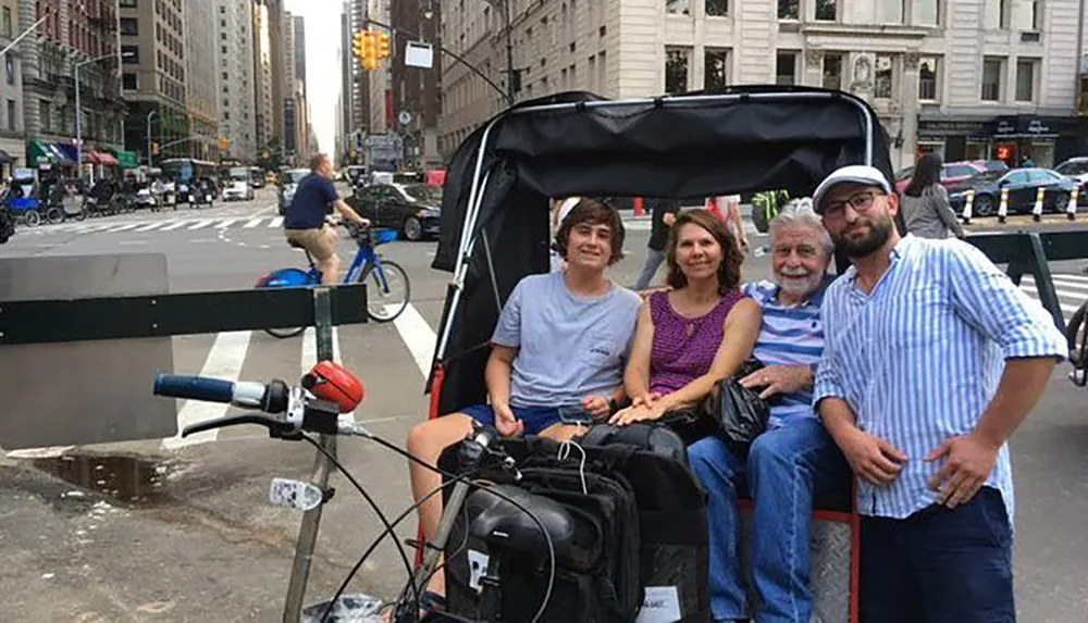 Three passengers are enjoying a ride in a pedicab with the driver standing beside them on a busy urban street