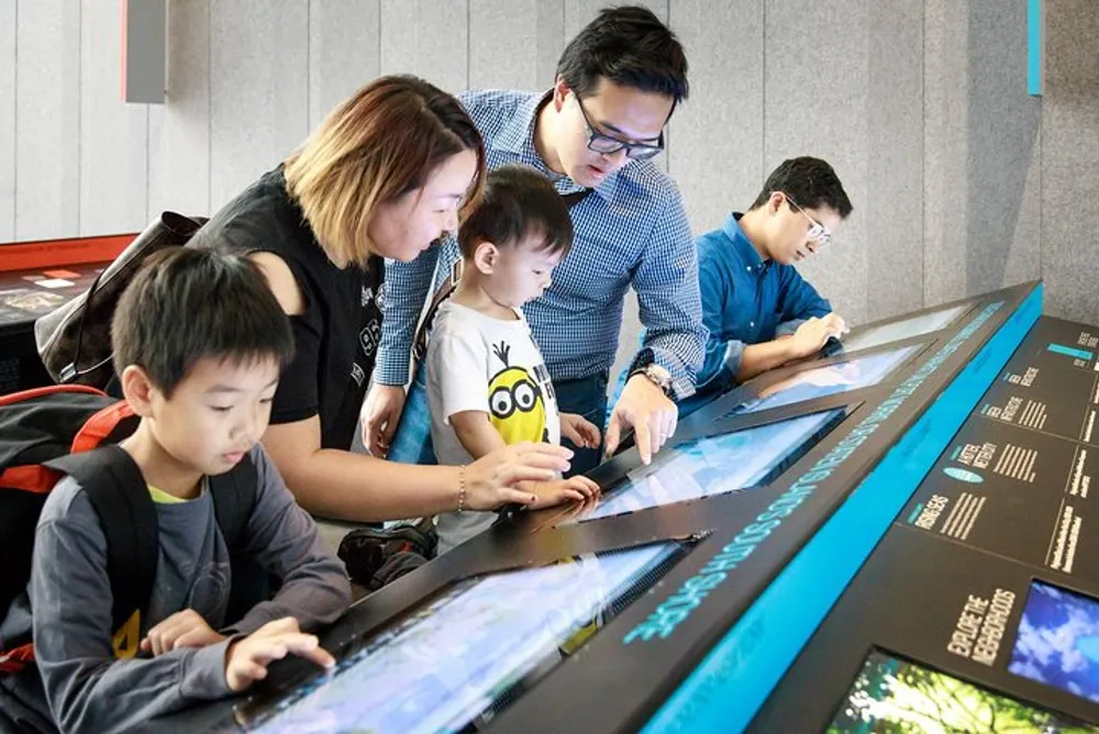 A family is interacting with a digital display at a modern educational exhibit