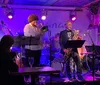 A jazz band performs on stage in an intimate venue with a cozy ambiance