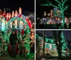 Visitors enjoy a festive display of Christmas decorations and illuminated figures at night