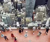 Visitors are enjoying a birds-eye view of a dense urban cityscape from an elevated observation deck