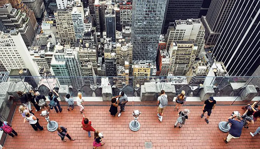 Visitors are enjoying a birds-eye view of a dense urban cityscape from an elevated observation deck