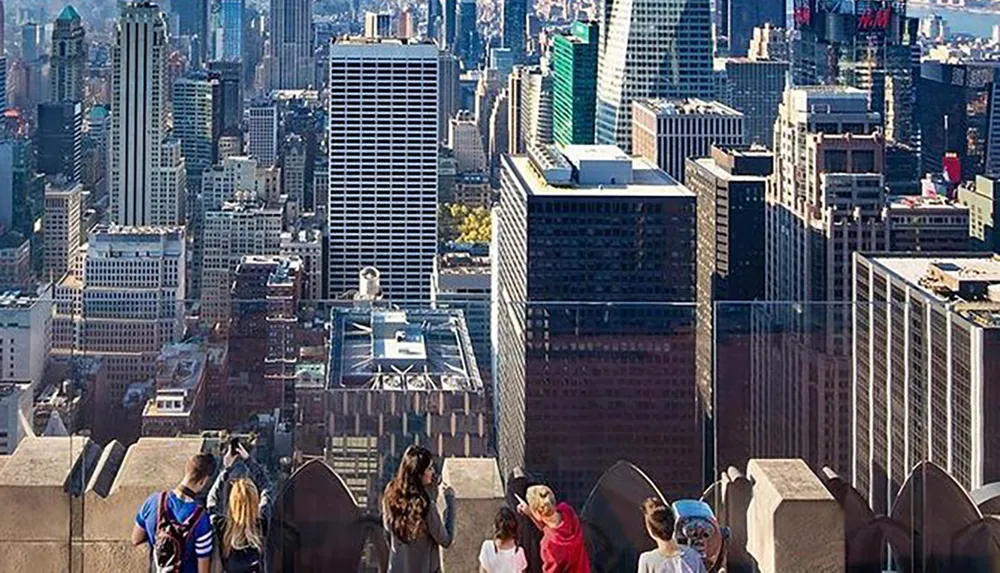 Visitors enjoy a panoramic view of a dense urban skyline from an elevated observation deck