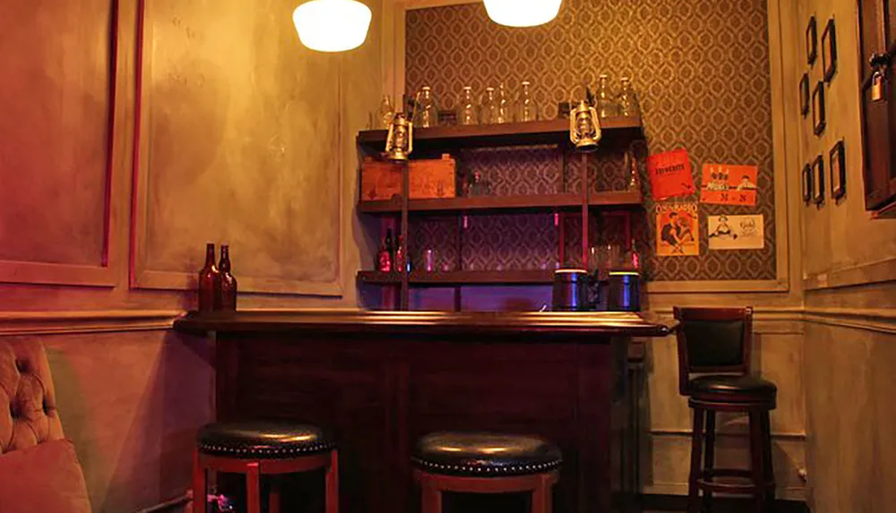 The image shows a cozy corner of a dimly lit bar with vintage decor including a wooden counter stools and old posters on the wall