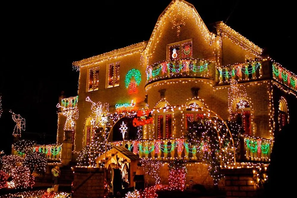 A house is extravagantly adorned with colorful Christmas lights and holiday decorations illuminating the night with festive cheer