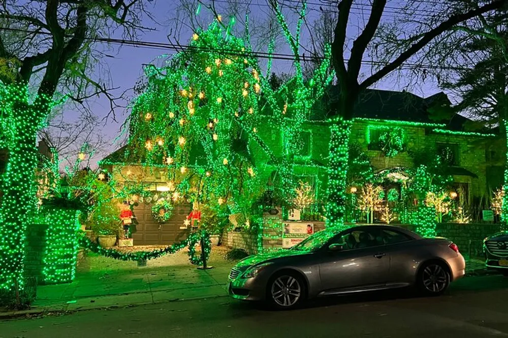 A house and its surrounding foliage are extravagantly adorned with numerous green lights creating a festive and vibrant night-time display