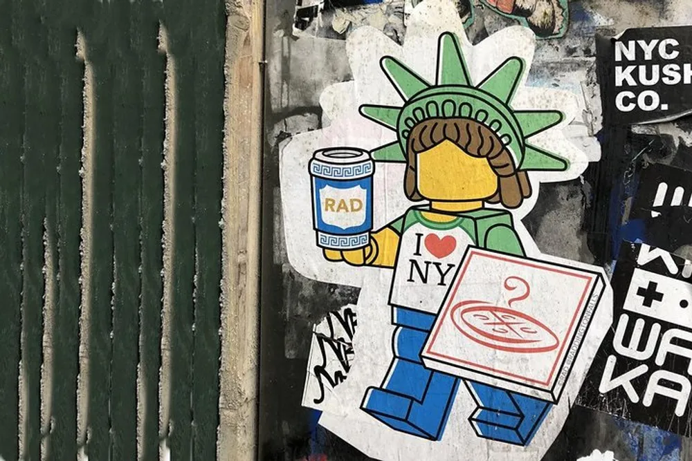 The image shows a sticker of a Lego minifigure styled as the Statue of Liberty holding a drink can and a pizza box with graffiti in the background