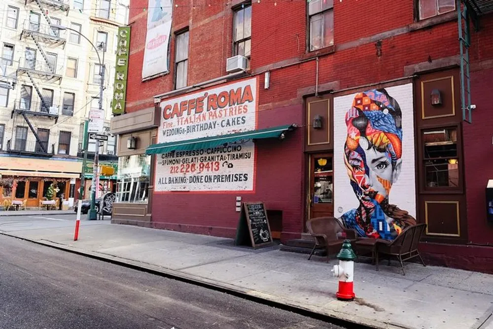 The image shows the exterior of Caff Roma featuring an artistic mural of a womans face on its sidewall with outdoor seating and signs advertising Italian pastries and coffee