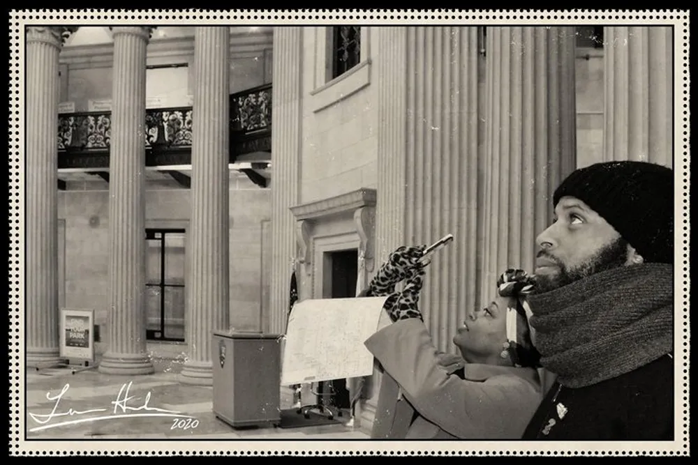 The image shows two people one holding a paper looking up towards something unseen with a look of concentration in a setting that resembles a museum or institution with classical architecture all presented in a sepia tone possibly to evoke a bygone era