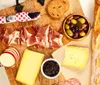 The image shows a delicious-looking charcuterie board with an assortment of meats cheeses olives jam and bread ideal for a gourmet snack or appetizer
