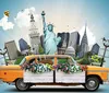 The image shows a whimsical montage of famous landmarks from around the world protruding from the back of a classic yellow taxi cab adorned with vibrant flower boxes set against a sky-blue background