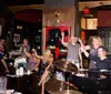 A lively group of people is celebrating and raising their glasses in a bar with live music