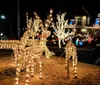 The image shows a house extravagantly decorated with a variety of illuminated Christmas decorations including Santa Claus figures reindeer lights and festive ornaments