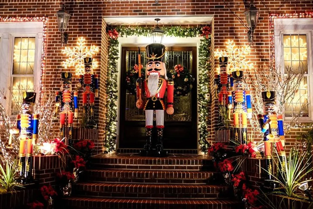 The image shows a festive holiday display at a residential entrance featuring a large nutcracker decoration flanked by smaller nutcrackers wreaths and twinkling lights on a brick facade