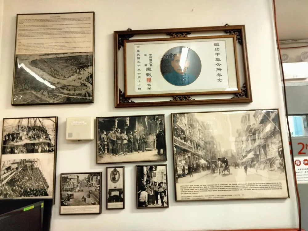 The image shows a wall adorned with multiple framed historical photographs and an accompanying description creating a display likely intended to convey a sense of historical context or reminisce about a certain place or era